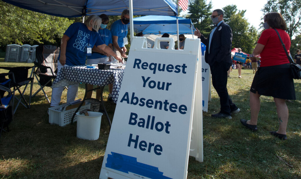 A sign advertises that a voter can request an absentee ballot. There have been recent mass voter challenges that cannot legally be processed within the pre-election freeze period, per state and federal law.