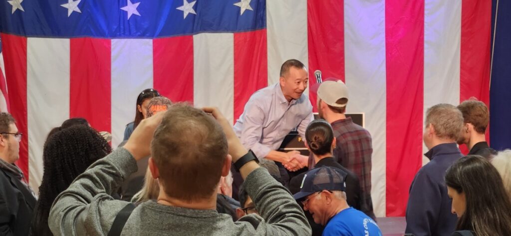 Democratic candidate Lanon Baccam shakes a supporter's hand at the close of his Monday rally.