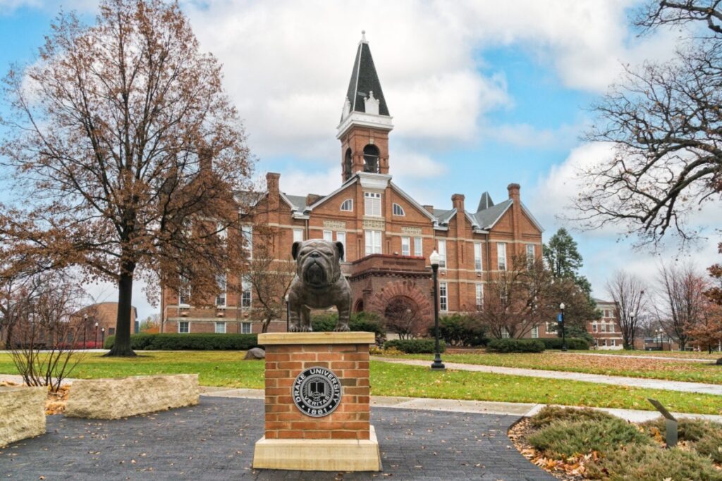 Bulldog mascot statue and Old Main on the campus of Drake University.